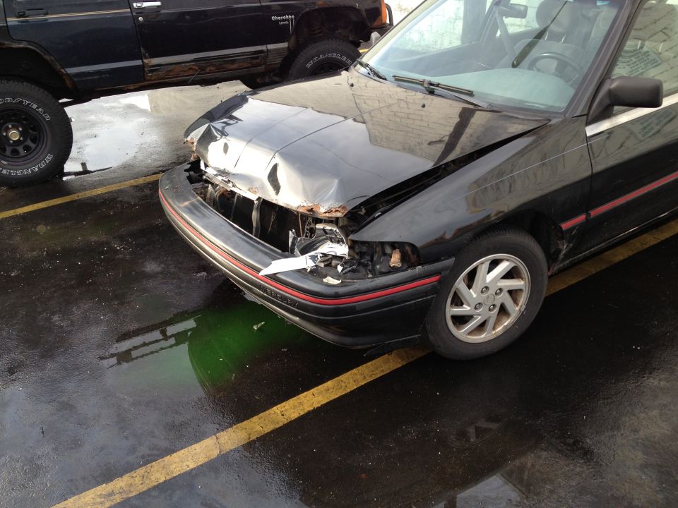 damaged black sedan parked next to a black SUV