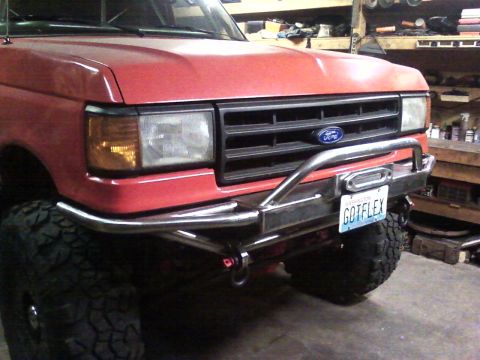 1989 Ford Bronco - This red Ford truck features a custom front bumper with a winch and a personalized license plate.