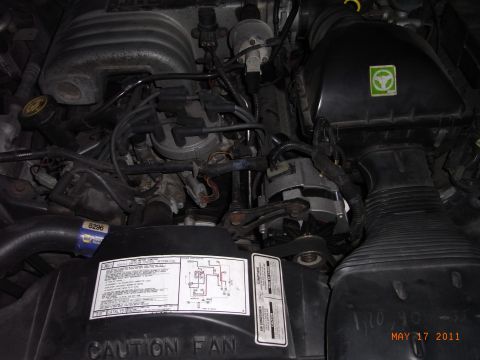 1991 Ford Crown Victoria LTD - Close-up view of a vehicle's engine bay, showing various components and a caution label.