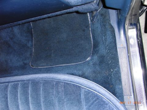 1991 Ford LTD Crown Victoria - Close-up view of the blue carpet and seat interior, showing a clear floor mat and door sill.