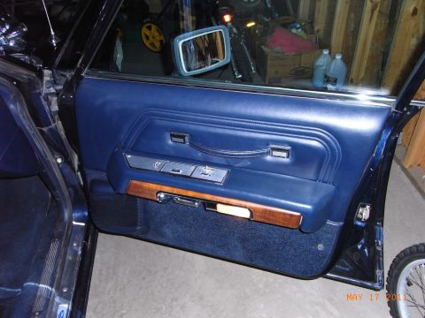 1991 Ford LTD Crown Victoria - Interior view of a car door panel, showing blue upholstery and wood trim details.