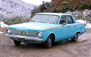 1970 Ford Ranchero - A light blue 1964 sedan is parked on a dirt road with snow-covered hills in the background.