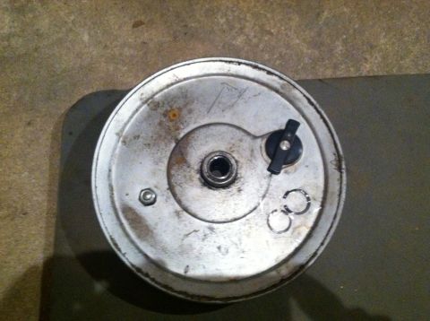 1981 Garelli Rally Sport - This is a close-up view of a round metal component, possibly from a moped or motorcycle, resting on a concrete surface.