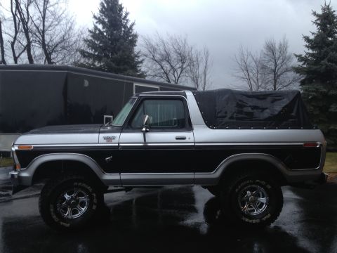 1979 Ford Bronco - This two-tone Ford Bronco, likely a 1978 model, is shown from the side with a black soft top covering the rear.