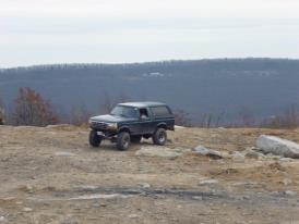 1995 Ford Bronco - Ford Bronco parked on a rocky hill, with a Supermotors watermark visible.