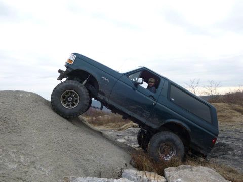 1995 Ford Bronco - This 1995 Ford Bronco is navigating a challenging off-road course on a rocky hill.