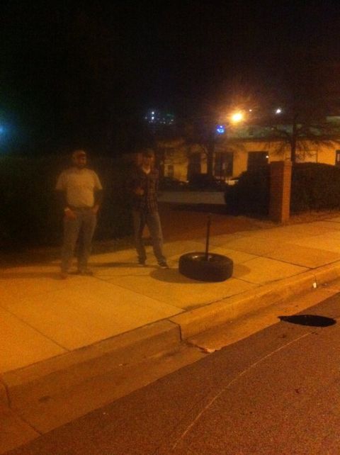 1995 Ford Bronco - Two men and a tire are on a sidewalk at night with a building in the background.