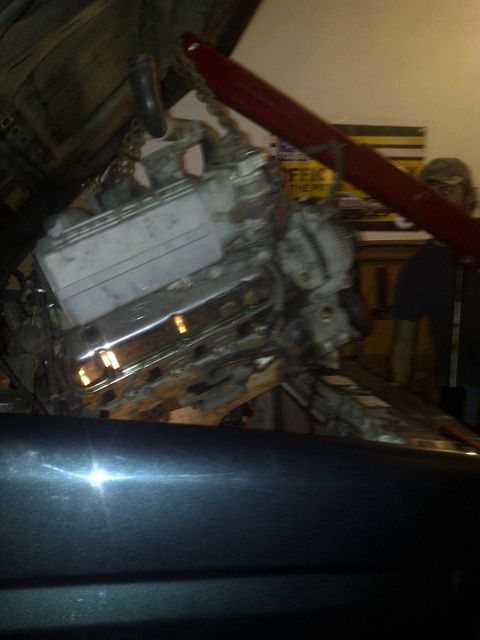 1995 Ford Bronco - Engine installation in progress, with a red hoist supporting the motor.