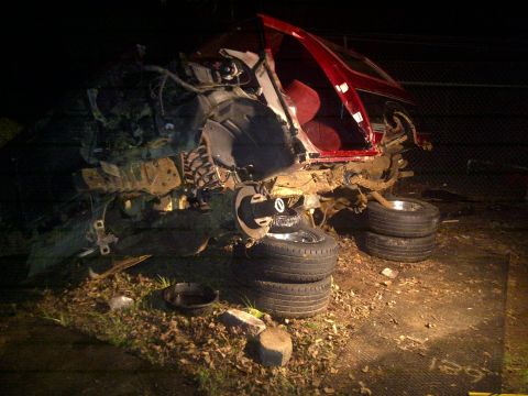 1995 Ford Bronco - This heavily damaged red SUV is missing its front end and appears to be undergoing salvage or repair.