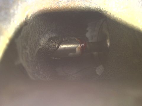 1995 Ford Bronco - A close-up view of an engine component, possibly a valve or actuator, with some red fluid present.