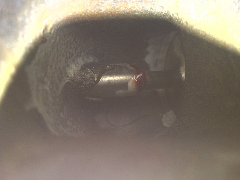 close-up of a metal engine component with some red fluid on it
