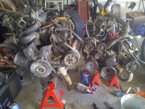 1995 Ford Bronco - Two V8 engines are displayed on jack stands, suggesting a workshop or parts inventory.