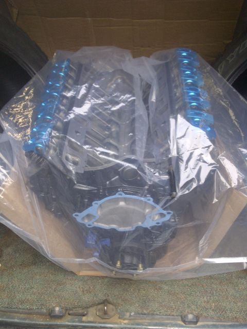 1995 Ford Bronco - A new engine is shown covered in plastic, ready for installation.