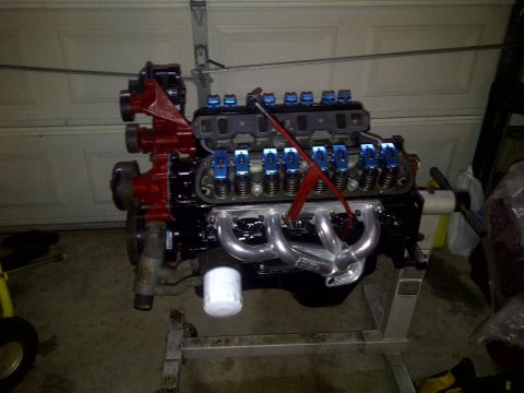 1995 Ford Bronco - A Ford V8 engine is mounted on an engine stand in a garage, ready for installation or work.