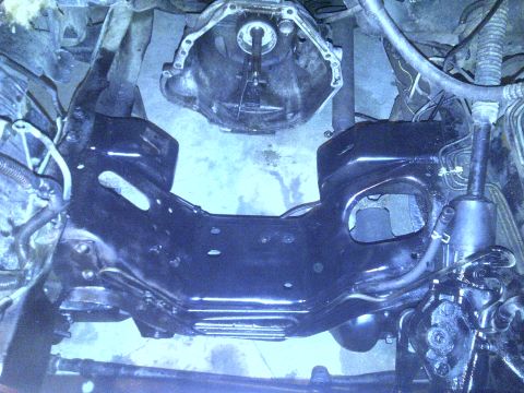 1995 Ford Bronco - The image shows the transmission housing and part of the vehicle's frame, with some hoses and wiring visible.