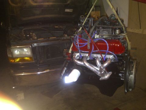 1995 Ford Bronco - Engine removal from a truck with a chrome bumper and amber turn signals.