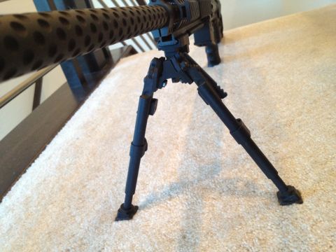 2013 Ford Mustang - Close-up of a machine gun bipod resting on a carpeted surface.