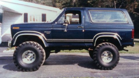 1995 Ford Bronco - This lifted 1995 Ford Bronco features a dark blue exterior and aggressive off-road tires, ready for any terrain.