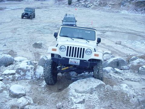 1992 Ford Bronco - Multiple off-road vehicles traverse a challenging, rocky landscape.
