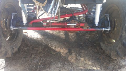 1978 Ford Bronco - Close-up view of the modified steering and suspension system, red-painted components and large off-road tires.