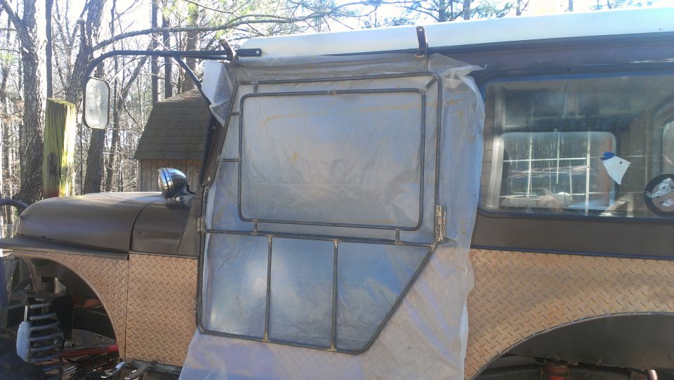1978 Ford Bronco door frame with plastic sheeting, diamond plate fender, and side mirror