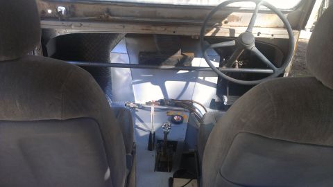 1978 Ford Bronco - The interior of a vehicle shows custom modifications and a floor-mounted shifter.