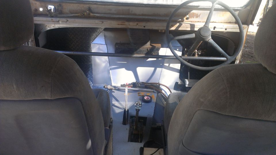 Interior of a modified vehicle with bucket seats, a steering wheel, and a floor shifter