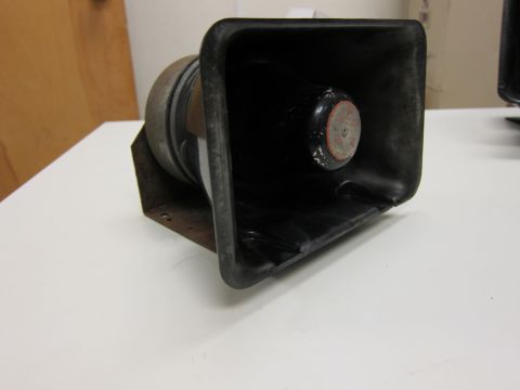 2001 Ford Crown Victoria - A close-up view of a siren speaker, showing its black horn and metal mounting bracket.
