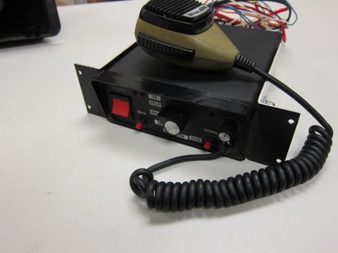 2001 Ford Crown Victoria - Close-up of a police siren control unit and microphone, showing various function labels and buttons.