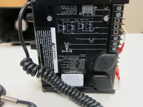 2001 Ford Crown Victoria - Close-up of a black siren control unit, showing wiring diagrams and warning labels.