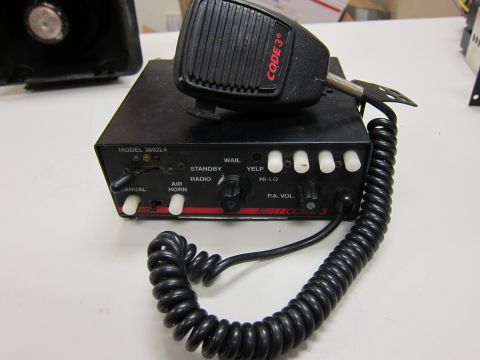 2001 Ford Crown Victoria - Emergency vehicle siren control box and microphone with various function buttons and knobs.