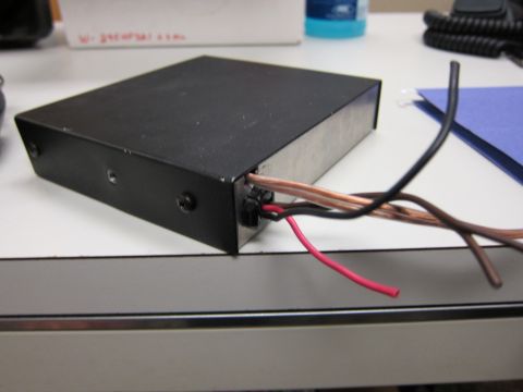 2001 Ford Crown Victoria - A black electronic device with multiple wires protruding from its casing sits on a desk.