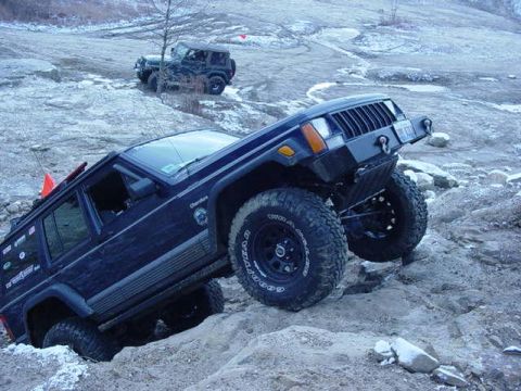 1992 Ford Bronco - Two Jeeps navigate a challenging off-road course with steep inclines and loose rocks.