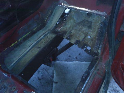 1978 Ford Bronco - The floor pan of a vehicle is shown undergoing repair work, with exposed metal and structural elements visible.