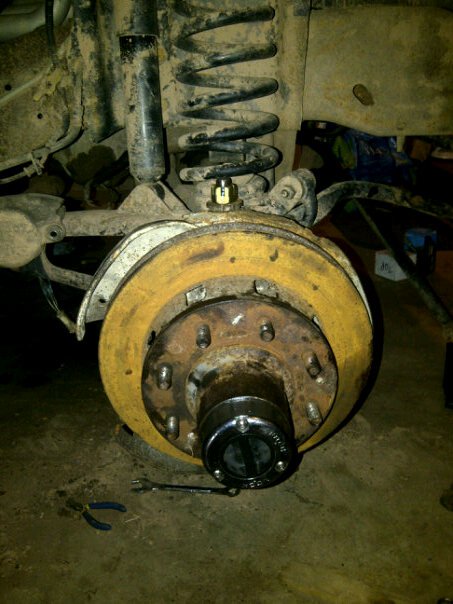 1995 Ford Bronco - Close-up view of a vehicle's brake rotor and suspension system, showing wear and tear.