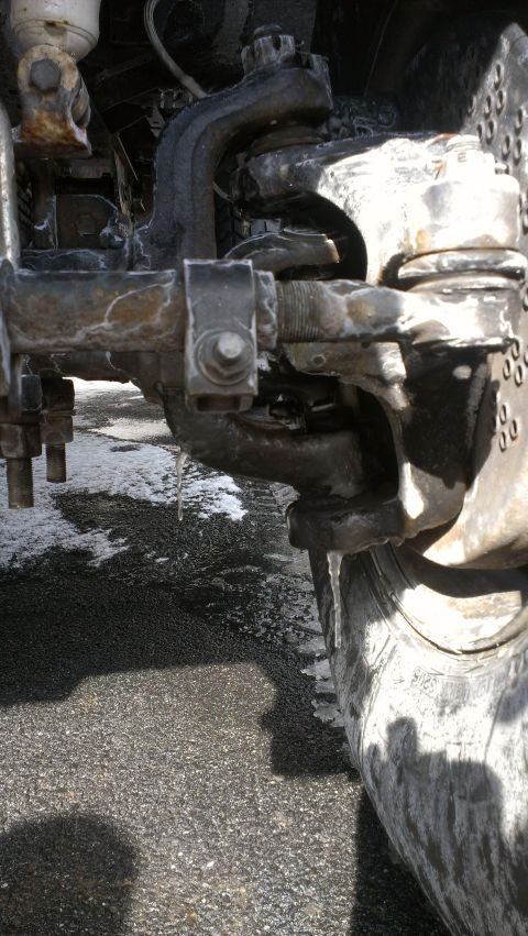 1995 Ford Bronco - The vehicle's front suspension and tire are covered in ice, with icicles forming on the components.