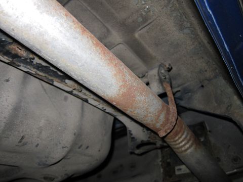 1991 Ford LTD Crown Victoria - Close-up of the undercarriage shows a heavily rusted exhaust system and fuel tank.