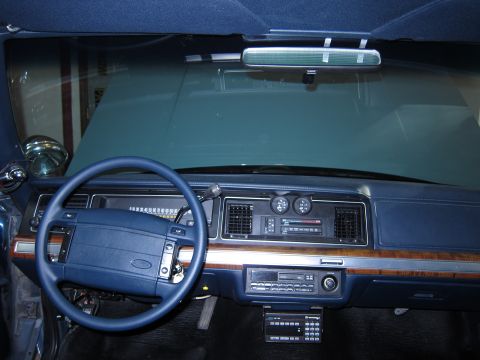 1991 Ford LTD Crown Victoria - The interior of a 1991 Ford Crown Victoria LTD police car, its dashboard, steering wheel, and radio equipment.