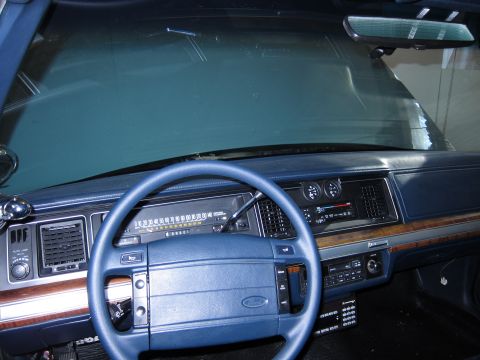 1991 Ford LTD Crown Victoria - The interior of a 1991 Ford Crown Victoria LTD, its blue dashboard, steering wheel, and clear instrument panel.