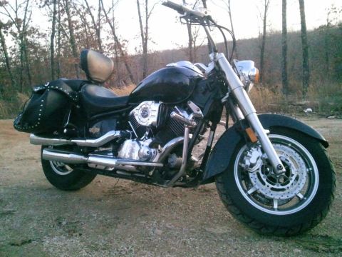 1995 Ford F-150 - A black cruiser motorcycle is parked outdoors on a dirt surface with trees in the background.