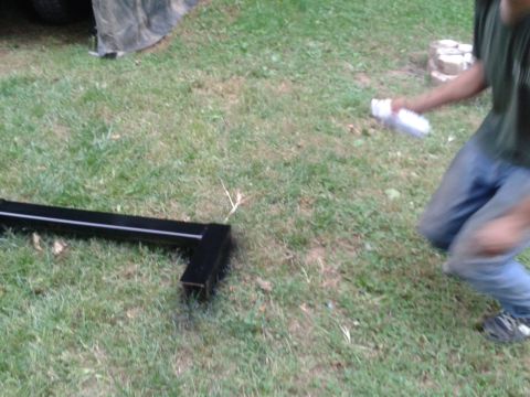 1995 Ford Bronco - A person in blue jeans and a dark t-shirt is kneeling on the grass, holding a white spray can. A black metal object is lying on the grass i…