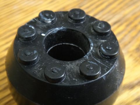 2000 Lincoln Continental - Close-up view of a black automotive suspension component a circular design with multiple raised elements.