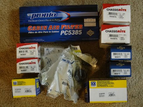 2000 Lincoln Continental - A collection of automotive parts, including a Pronto cabin air filter and various suspension components from different brands, laid out on…