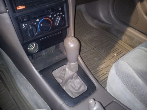 1998 Toyota Camry - The interior of a vehicle shows the center console, gear shifter, and climate controls.