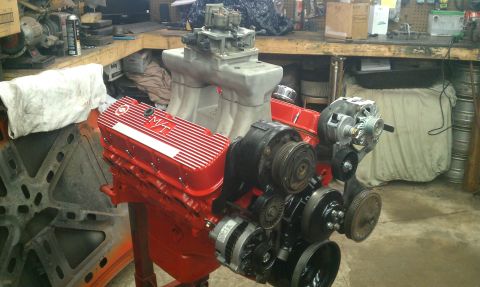 1990 Chevrolet Silverado 1500 - V8 engine assembly on a stand, M/T valve covers and dual carburetors.