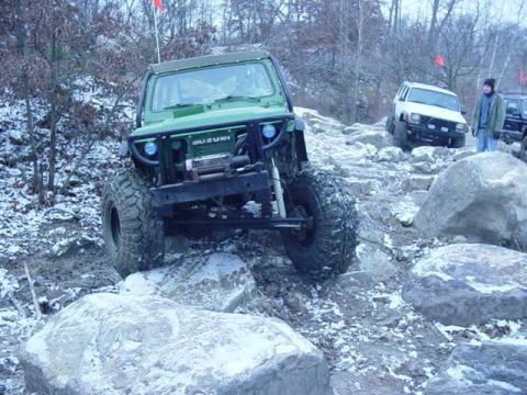 1992 Ford Bronco - This modified Suzuki Samurai navigates a challenging rocky terrain covered in snow.