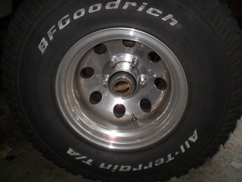 1990 Ford Bronco - Close-up of a BFGoodrich All-Terrain T/A tire and chrome wheel, Warn locking hubs.