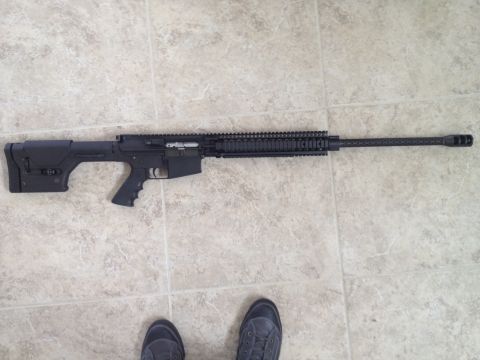 2013 Ford Mustang - A rifle is shown on a tiled floor, with a person's feet visible at the bottom.