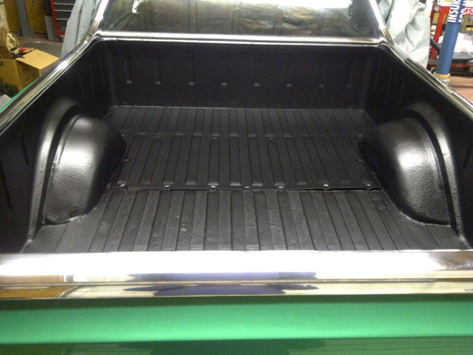 Green 1971 Ford Ranchero truck bed interior with black liner and chrome rails