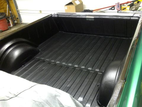 1971 Ford Ranchero - Newly applied black spray-on bed liner covers the floor and wheel wells of a pickup truck.